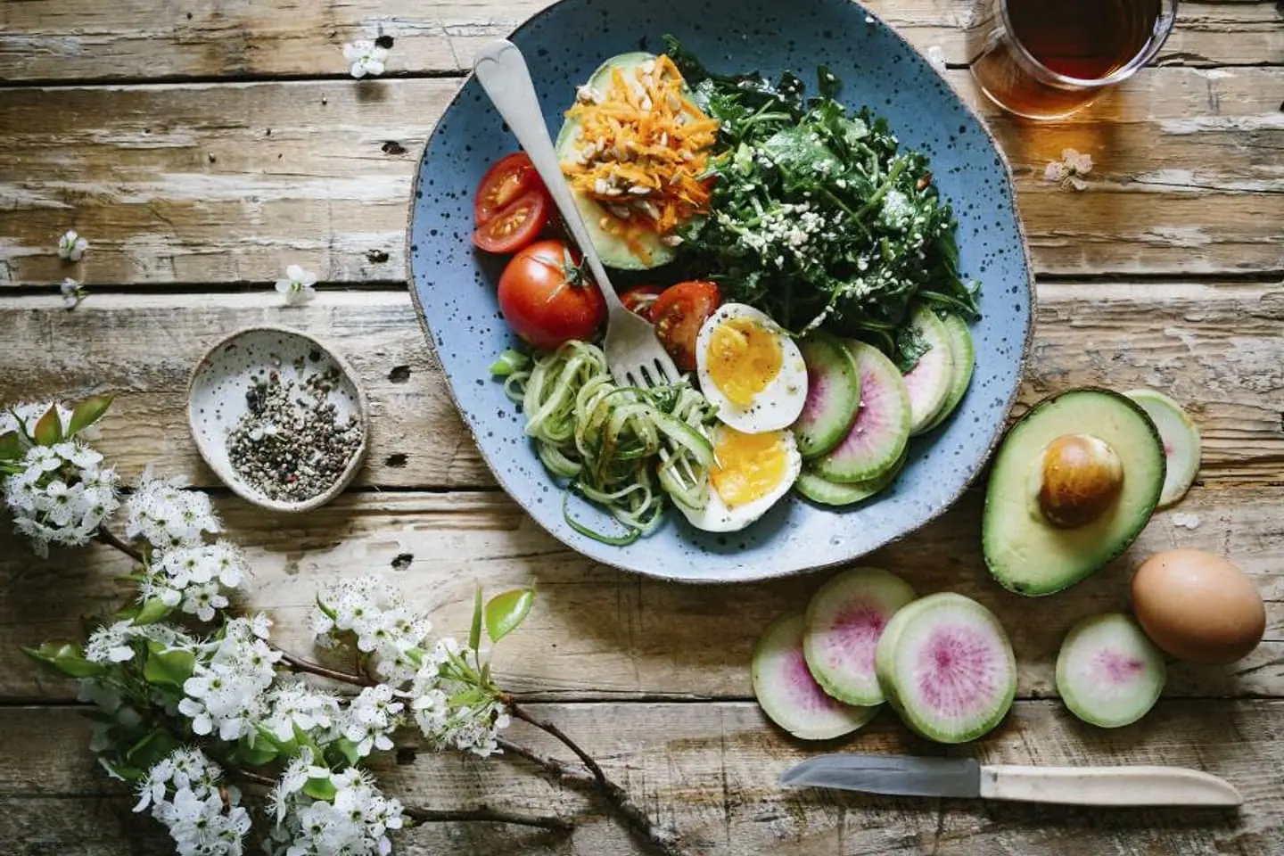 Bowl mit Ei, Avocado, Radieschen und Kräutern von oben fotografiert
