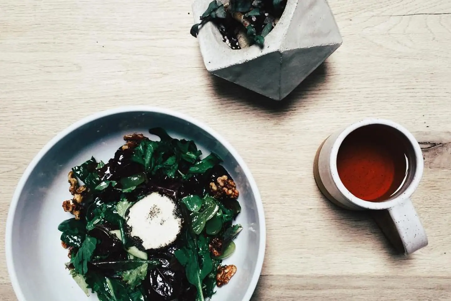 Salat mit Ziegenkäse und eine Tasse Tee von oben fotografiert