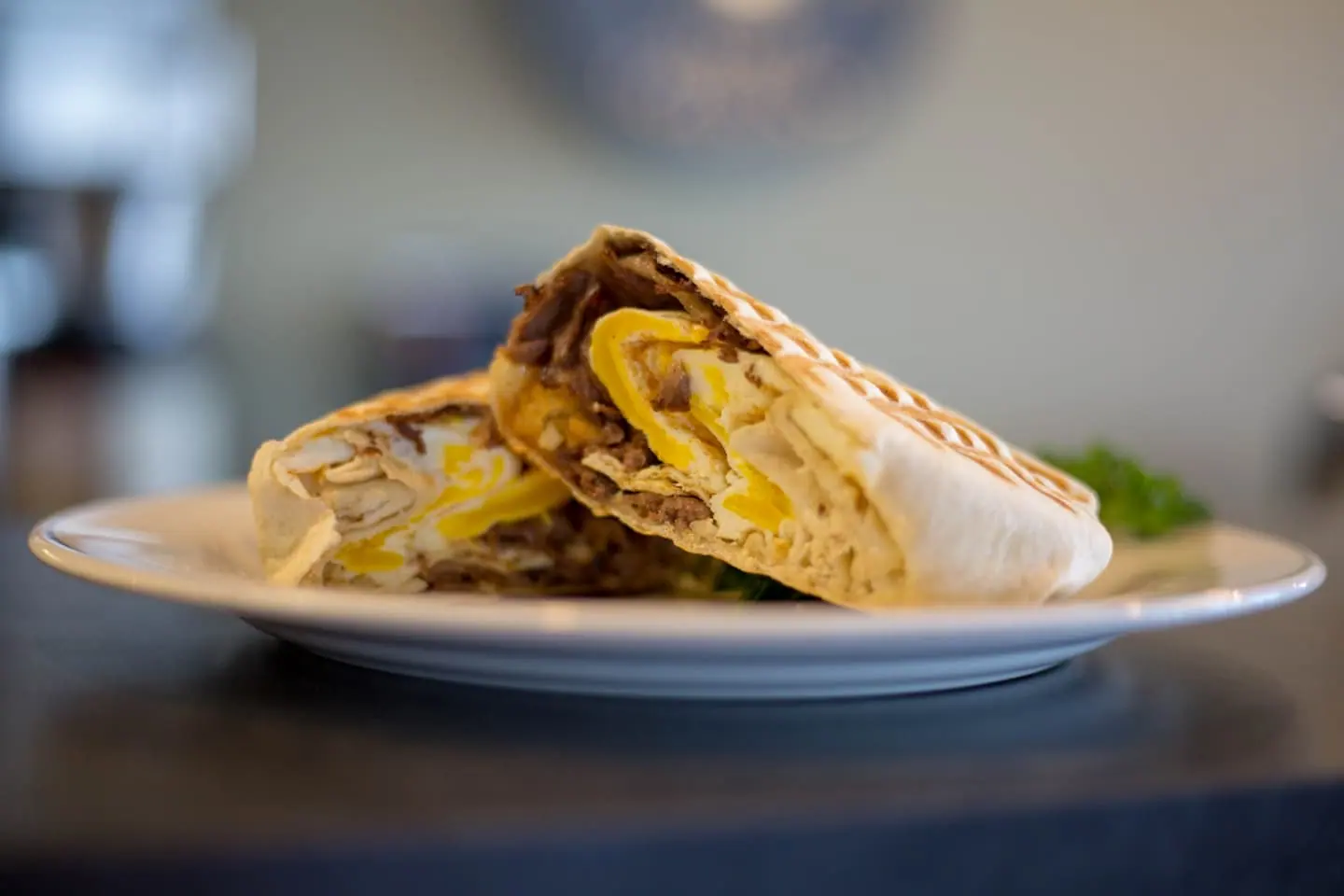 Halbierter Wrap mit knusprigem Hähnchen auf einem Teller