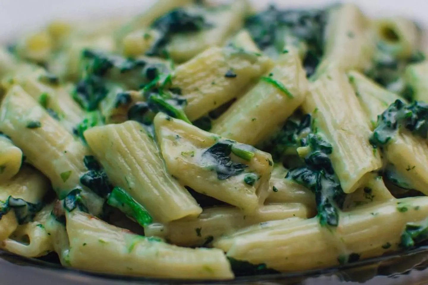 Cremige grüne Pasta mit Spinat und Basilikum in einer Pfanne