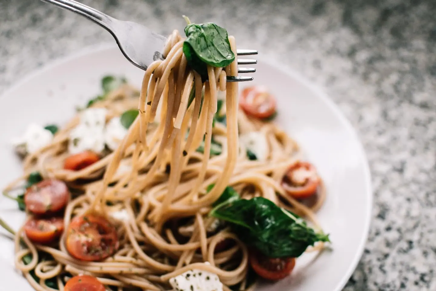 Spaghetti mit Tomaten und Spinat, um eine Gabel gedreht